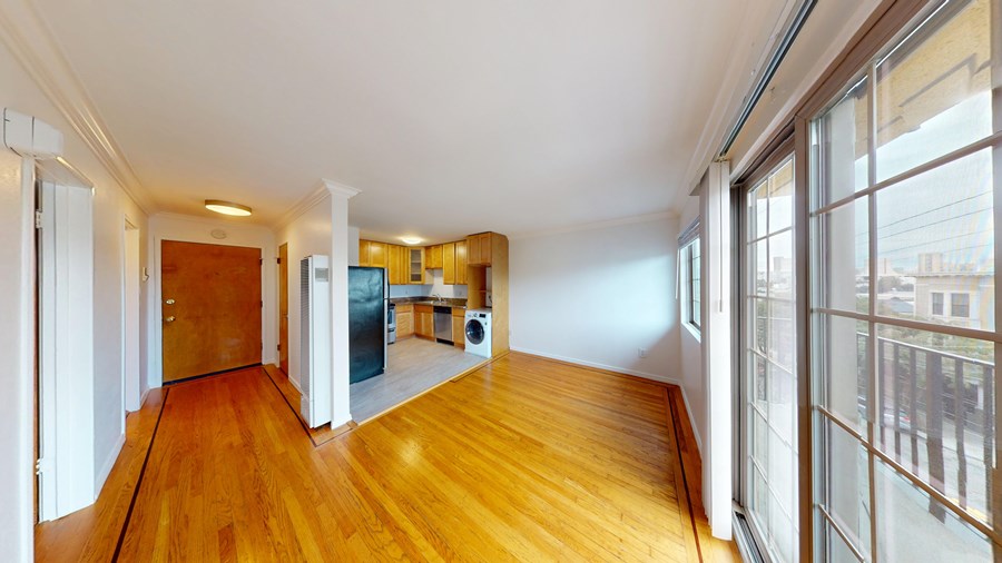 A room with wooden floors and a large window.